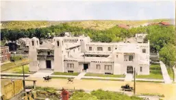  ?? COURTESY OF NEW MEXICO MUSEUM OF ART ?? This hand-colored photograph by Evan C. Douglas shows the New Mexico Museum of Art around 1920. Note the horses on Palace Avenue, unpaved roads, an empty or gutted lot across the street and the number of residentia­l homes nearby with no semblance to...