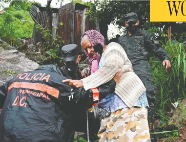  ?? ORLANDO SIERRA / AFP VIA GETTY IMAGES ?? Police officers help an elderly woman in Tegucigalp­a, Honduras, as Hurricane Iota moved toward the country Tuesday.