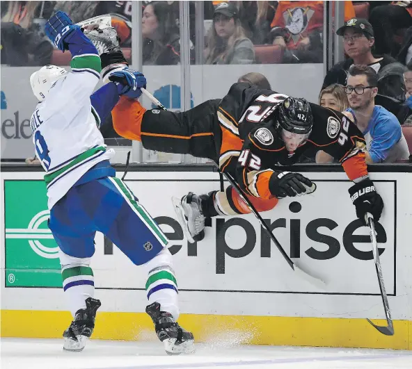  ?? — THE ASSOCIATED PRESS ?? Vancouver Canucks right winger Jack Skille, left, trips up Anaheim Ducks defenceman Josh Manson during the third period Sunday in Anaheim, Calif. The Ducks won 4-2, as Canucks goalie Ryan Miller faced 37 shots.