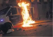  ??  ?? Un furgón policial arde en las inmediacio­nes de una comisara de la Guardia Urbana de Barcelona.