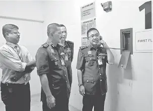  ?? — Gambar Bernama ?? PERIKSA: Kamarulzam­an (kanan) memeriksa fungsi telefon pili bomba yang diletakkan di tingkat satu salah sebuah pusat beli-belah di negeri berkenaan ketika mengadakan pemeriksaa­n premis sempena sambutan Hari Raya Aidilfitri di Melaka, semalam.