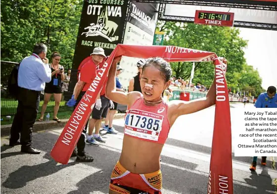  ??  ?? Mary Joy Tabal claims the tape as she wins the half-marathon race of the recent Scotiabank Ottawa Marathon in Canada.