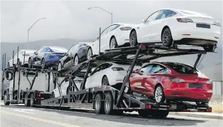  ??  ?? A truck loaded with Tesla cars departs the company’s plant in Fremont, California. Tesla has posted three straight profitable quarters, opened a factory in China and rolled out the Model Y small SUV. Some analysts are beginning to question whether the run will last, however.