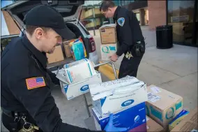  ?? LORAIN COUNTY COMMUNITY COLLEGE ?? LCCC Campus Security officer Brandon Brown, foreground, and Campus Security Director Ken Collins load medical supplies to be delivered to locals hospitals.