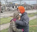  ?? AP PHOTO ?? Residents Valerie Mcavoy with daughter Jayda Weathersby, 9, hug as they survey tornado damage of their neighborho­od in Naplate, Ill., on Wednesday