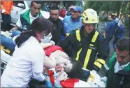  ?? RICARDO MAZALAN / AP ?? An injured woman is evacuated on a gurney after an explosion at the Centro Andino shopping center in Bogota, Colombia, on Saturday.