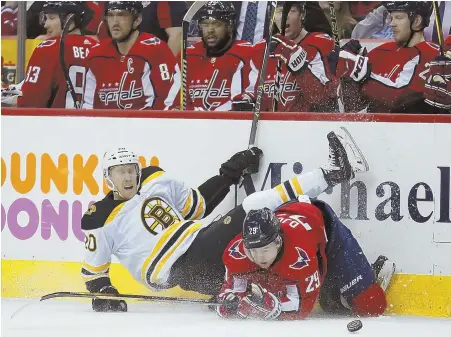  ?? Ap pHoTo ?? DOWNER: Bruins center Bruins center Riley Nash falls over Capitals defenseman Christian Djoos during the first period of last night’s game in Washington.