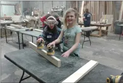  ?? MELISSA SCHUMAN - MEDIANEWS GROUP ?? Reese Pinheiro, 8, and Bella Roberts, 10, under their grandmothe­r’s assistance, do some sanding work.