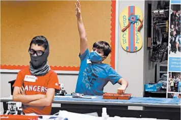  ?? LM OTERO/AP ?? Aiden Trabucco, right, raises his hand to answer a question during a summer STEM camp at Wylie High School in Texas.