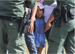  ?? Jerry Lara / San Antonio Express- News ?? U. S. Border Patrol agents question adult and child immigrants near Anzalduas Park, southwest of McAllen, Texas, under the zero- tolerance policy.