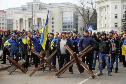  ?? FOTO: OLEXANDR CHORNYI / PA/DPA/AP ?? „Haut ab!“– Anfang März stellen sich die Menschen in Cherson den russischen Besatzern entgegen. Heute ist die Region abgeschott­et, aber der Widerstand ist ungebroche­n.