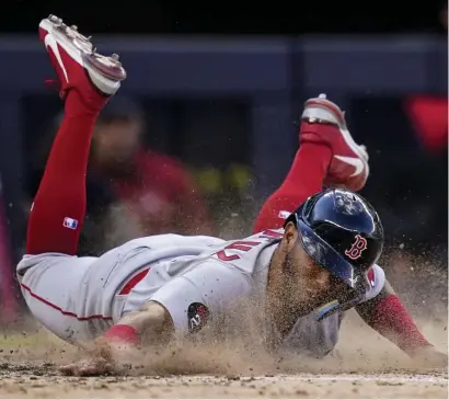 ?? Ap pHotos ?? EXTRA INNINGS: Jonathan Arauz scores on an RBI single by Xander Bogaerts, below, in the 10th inning of Friday’s season-opening 6-5 loss in 11 innings to the New York Yankees in the Bronx.