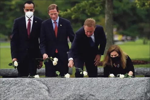  ?? Erik Trautmann / Hearst Connecticu­t Media ?? U.S. Sen. Richard Blumenthal, second from left, Gov. Ned Lamont and Lt. Gov. Susan Bysiewicz lay roses as they attend the state’s annual 9/11 Memorial Ceremony on Thursday at Sherwood Island State Park in Westport. The annual program honored and celebrated the lives of those killed in the Sept. 11, 2001, terrorist attacks.