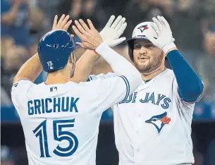  ?? NATHAN DENETTE THE CANADIAN PRESS ?? The Jays’ Rowdy Tellez, right, celebrates with Randal Grichuk after hitting a two-run homer during second-inning play Thursday night against the Rays. Tellez was 2-for-4 with three RBIs.