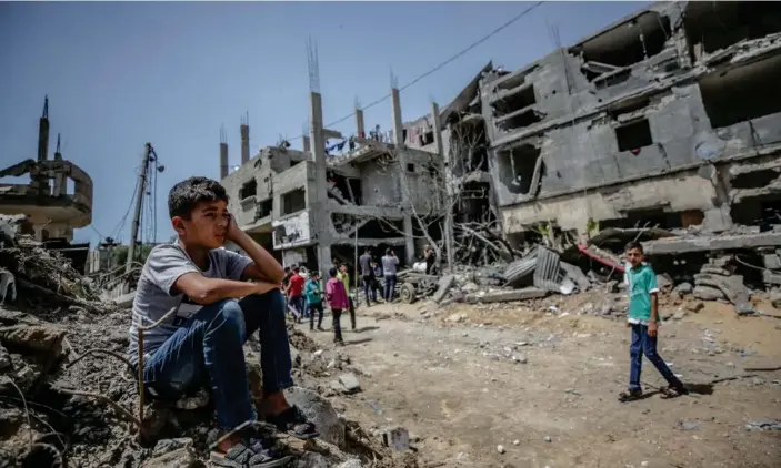  ??  ?? A Palestinia­n boy sits on the rubble of his house destroyed in an Israeli airstrike, in Beit Hanun, Gaza Photograph: Mohammed Saber/EPA