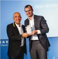  ??  ?? Meinrad Spenger, cofundador de MásMóvil, recibiendo el premio que le entregó Kike Sarasola, presidente de Room Mate Group.
