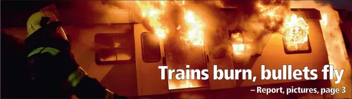  ?? PICTURE: JASON BOUD ?? ARSON: Flames erupt at Esplanade Station in Woodstock last night after two train carriages were set alight. At Cape Town Station, police fired rubber bullets at commuters angry about delays. Metrorail has declared that it is under siege.