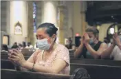  ??  ?? Claudia Balderas, 51, prays for her brother, who died from COVID-19 in May, on Monday, while attending the first inperson Mass in almost four months at Saint Bartholome­w Roman Catholic Church in the Queens borough of New York.