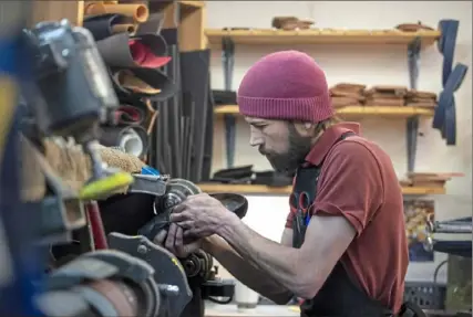  ?? Steph Chambers/Post-Gazette ?? Cobbler Chuck Carlson, 39, works on repairs March 7 in his shop, Fox Chapel Shoe Service, in O'Hara. Mr. Carlson, the area’s youngest cobbler, bought the shop from Mike Palermo, who trained him.