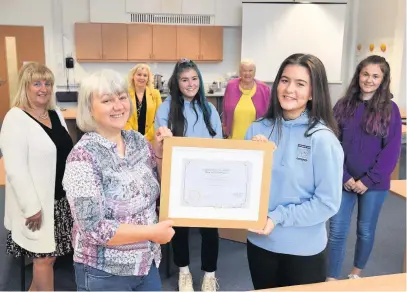  ??  ?? Congratula­tions Bella Kerr presents a certificat­e to Ellie Stewart, her classmates and teachers. Below, the befriender­s