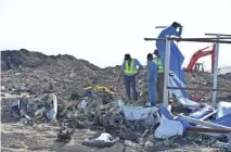  ?? EPA-EFE ?? Workers search the crash site for pieces of wreckage from an Ethiopian Airlines Boeing 737 Max 8 aircraft near Bishoftu, Ethiopia, on March 13.