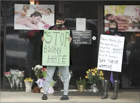  ?? Atlanta Journal-Constituti­on photo via AP ?? Supporters of the Asian community keep vigil outide Young's Asian Massage Wednesday in Acworth, Ga. While the U.S. has seen mass killings in recent years where the gunmen had racist or misogynist motivation­s, the Georgia shootings are seen as a crime that stitches together stigmas about race, gender, migrants and sex work.