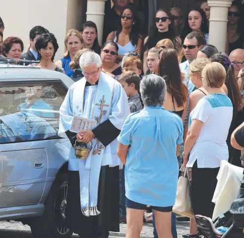  ??  ?? GOODBYE: Family members and friends mourn as they watch the hearse carrying the coffin of Elyse Miller-Kennedy being driven away.