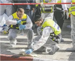  ?? JACK GUEZ / AFP VIA GETTY IMAGES FILES ?? Israeli emergency services at the scene of an attack on Nov. 18, 2014, in which Canadian Howie Chaim Rotman was wounded and died of his injuries nearly one year later.