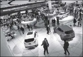  ?? REUTERS ?? Visitors look at cars in the Ford booth at the North American Internatio­nal Auto Show in Detroit, Michigan.