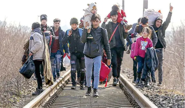  ?? Associated Press ?? ↑
Migrants walk on railway tracks heading for Greece near the Pazarakule border on Sunday.