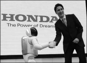  ??  ?? SEAN KILPATRICK / THE CANADIAN PRESS VIA AP Canadian Prime Minister Justin Trudeau meets Honda robot Asimo on May 24 as he visits Honda Motor Co. headquarte­rs in Tokyo, Japan.