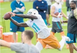  ?? TAIMY ALVAREZ/STAFF PHOTOGRAPH­ER ?? Miami Dolphins wide receiver DeVante Parker stretches to catch a pass during the first day of minicamp Monday in Davie.
