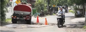  ?? JOS RIZAL/JAWA POS ?? LEWAT PINGGIR: Pengendara menghindar­i lubang di tengah Jalan Balongsari Tama.