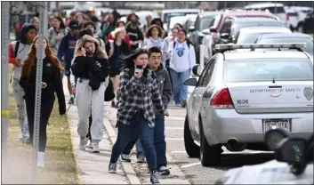  ?? HYOUNG CHANG — THE DENVER POST ?? Students leave Denver’s East High School after a shooting there on Wednesday. DPS Superinten­dent Alex Marrero announced later that two armed officers will be at East for the rest of the school year.