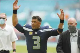  ?? AP photo ?? Seahawks quarterbac­k Russell Wilson raises his arms as fans cheer at the end of Seattle’s 31-23 win over the Miami Dolphins on Sunday.