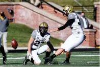  ?? AP Photo/L.G. Patterson ?? ■ Vanderbilt’s Sarah Fuller, right, kicks off as Ryan McCord (27) holds Saturday to start the second half of an NCAA football game against Missouri in Columbia, Mo. With the kick, Fuller became the first female to play in a Southeaste­rn Conference football game.