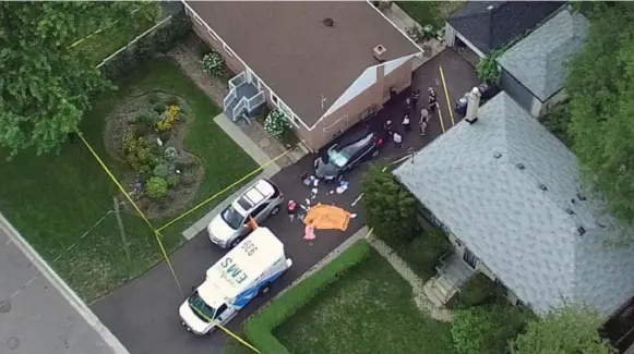  ?? PASCAL MARCHAND ?? A victim is covered by a tarp in the driveway of a bungalow in Scarboroug­h on Thursday. Neighbours say a middle-aged couple lived in the home where the deaths occurred.