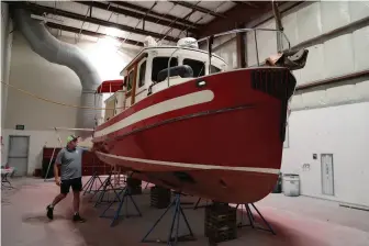  ?? ?? Top to bottom: A Nordic Tug got a new paint job; the yard and its docks sit on Hayden Island’s Canoe Bay with access to the Columbia River; Schooner Creek owner Kevin Flanigan has diversifie­d the business since taking over in 2015.