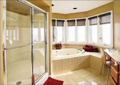  ?? Bob Donaldson/Post-Gazette photos ?? Above: The master bathroom offers a separate shower with glass doors and jetted tub surrounded by tall windows. Top right: The front of the property.