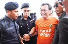  ??  ?? Shafie being escorted into the Kota Kinabalu High Court. - Bernama photo