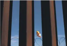  ?? AFP ?? A Trump balloon at the US-Mexico border fence