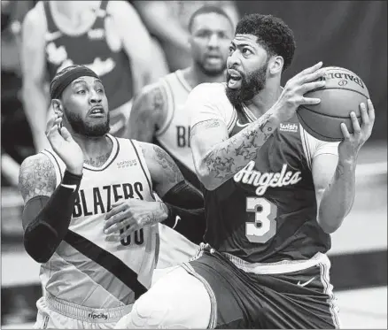  ?? Craig Mitchelldy­er Associated Press ?? ANTHONY DAVIS, right, drives on the Trail Blazers’ Carmelo Anthony during the Lakers’ 106-101 loss on Friday in Portland, Ore.