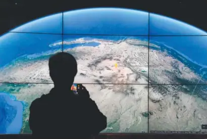  ??  ?? A man looks at a Google Earth map on a screen as Google Earth unveils the revamped version of the applicatio­n at an event Tuesday at New York’s Whitney Museum of Art. Timothy A. Clary, AFP/Getty Images