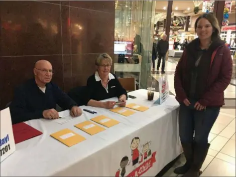  ?? TYLER RIGG — THE NEWS-HERALD ?? Sandy and Don Berlin help a volunteer shopper, Tessa, get started Dec. 17 for the Clothe-A-Child charity.