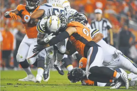  ?? Helen H. Richardson, The Denver Post ?? Melvin Gordon of the Los Angeles Chargers is stopped by Broncos defensive lineman Adam Gotsis during the fourth quarter Monday night at Sports Authority Field at Mile High.