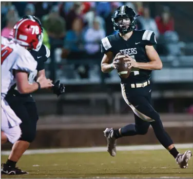  ?? (NWA Democrat-Gazette/Caleb Grieger) ?? Charleston quarterbac­k Carter Little (right) rolls to his left Friday as he looks downfield to throw a pass during a 14-7 victory over Mansfield at Alumni Field in Charleston.