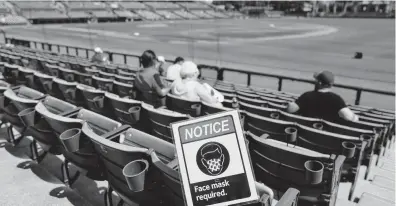  ?? BRYNN ANDERSON/AP ?? A sign requiring masks is seen in the seats during a spring training game between the Yankees and Orioles in Sarasota, Florida.