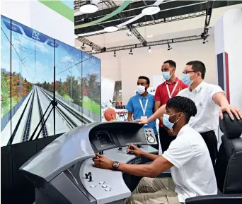  ?? ?? An African visitor to an expo in Tianjin tries a train-driving simulator at a Luban Workshop booth on 28 August 2022