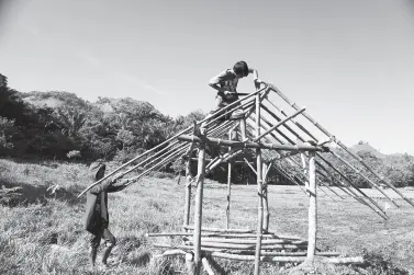  ??  ?? A FATHER and his son build a shed by the ricefield in Manolo Fortich, Bukidnon on Friday. MindaNews photo by BOBBY TIMONERA