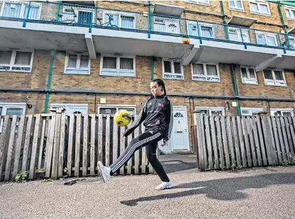 ??  ?? Autumn Harvey, 12, plays football outside her family flat in Manor Park, east London. Restrictio­ns mean she cannot train with her teammates for four weeks